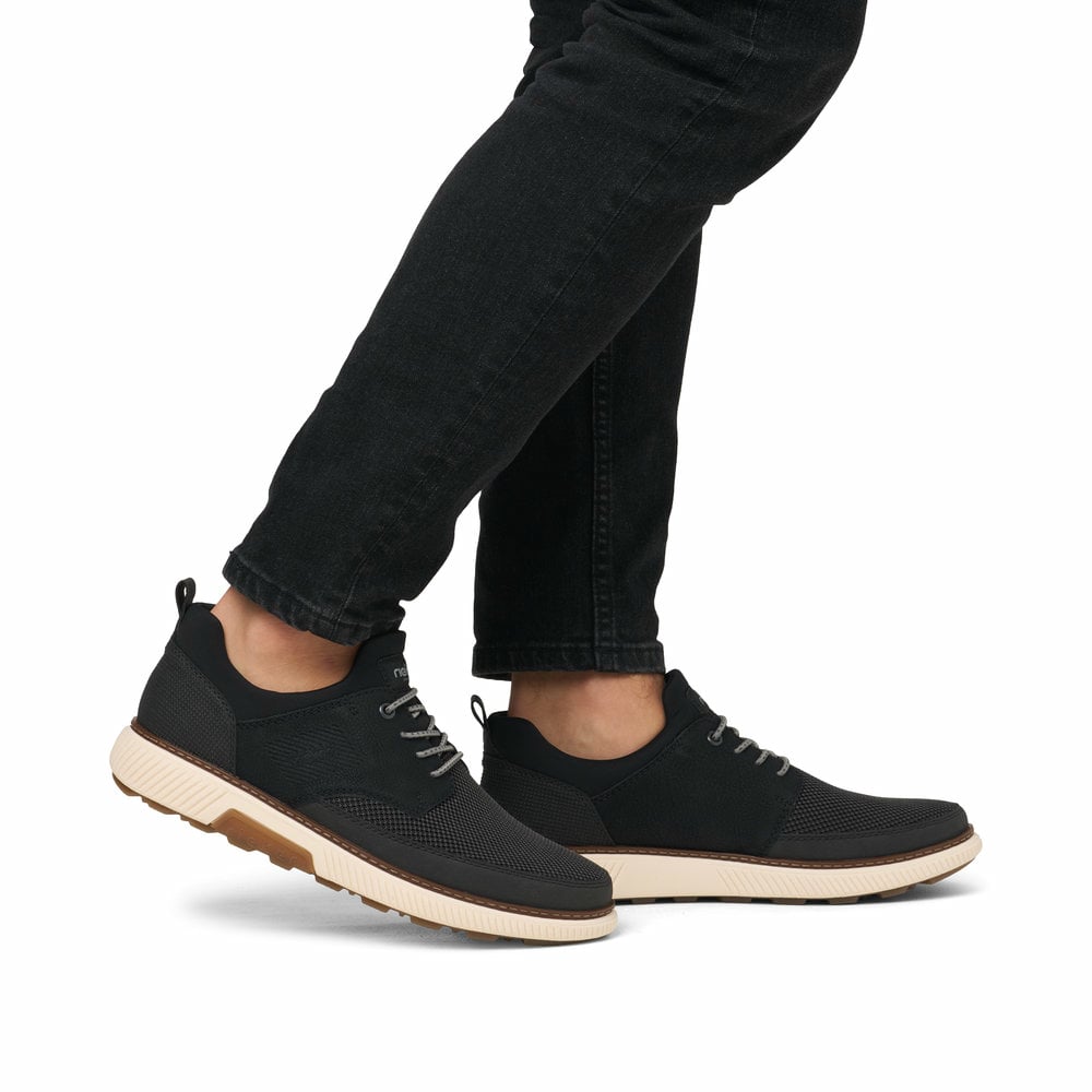 Schwarze Rieker Herren Slipper B3354-00 mit einem Gummizug sowie Extraweite H. Schuh am Fuß.