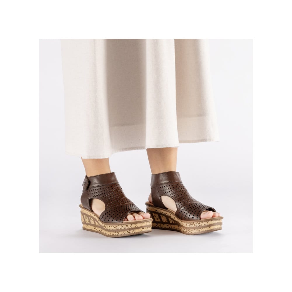 Braune Rieker Keilsandaletten 68185-24 mit raffinierten Cut-Outs. Schuh am Fuß.