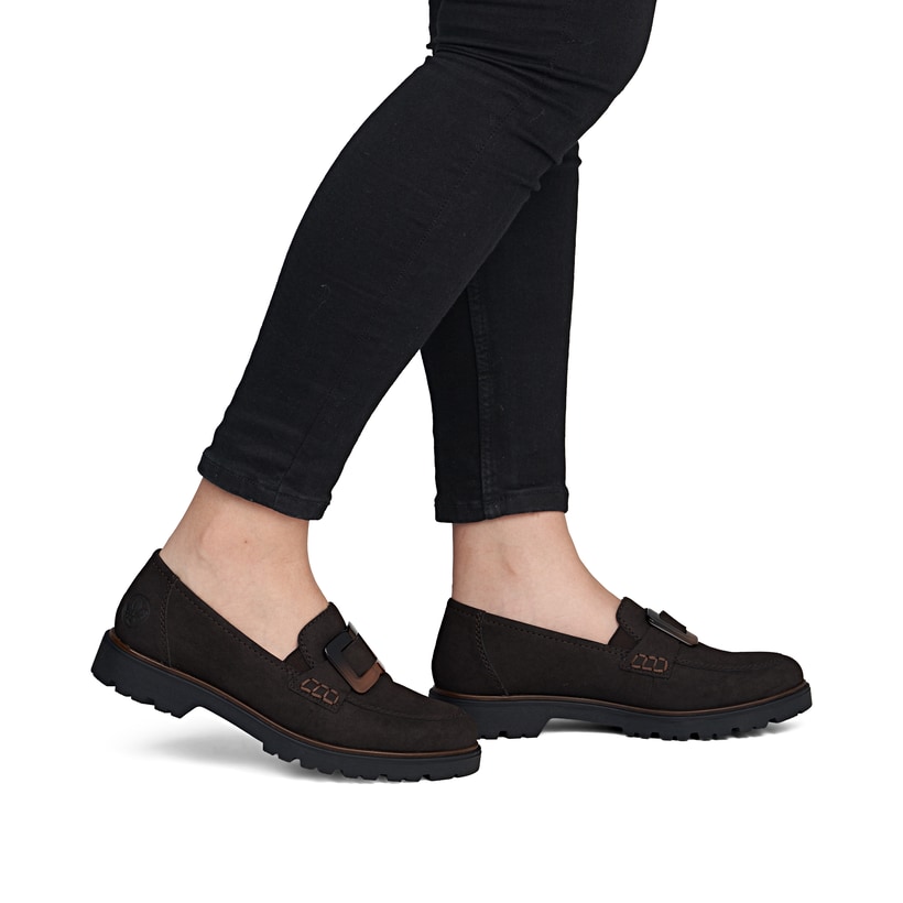 Dunkelbraune Rieker Damen Loafer 45553-25 mit Schmuckelementen sowie Gummizug. Schuh am Fuß.