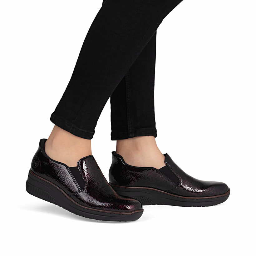 Rote Rieker Damen Slipper 48761-35 mit einem Gummizug sowie schmaler Passform E. Schuh am Fuß.