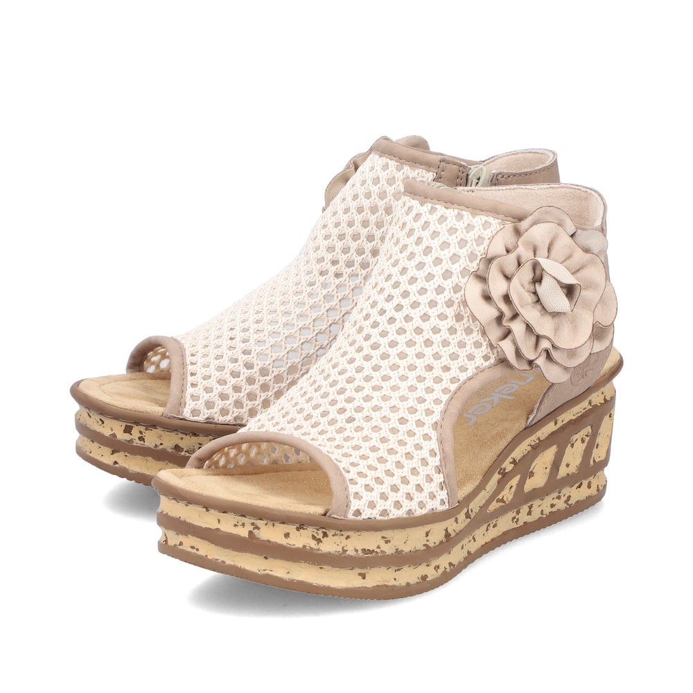 Beige Rieker Keilsandaletten 68180-60 mit dekorativer Blume sowie Reißverschluss. Schuhpaar seitlich schräg.