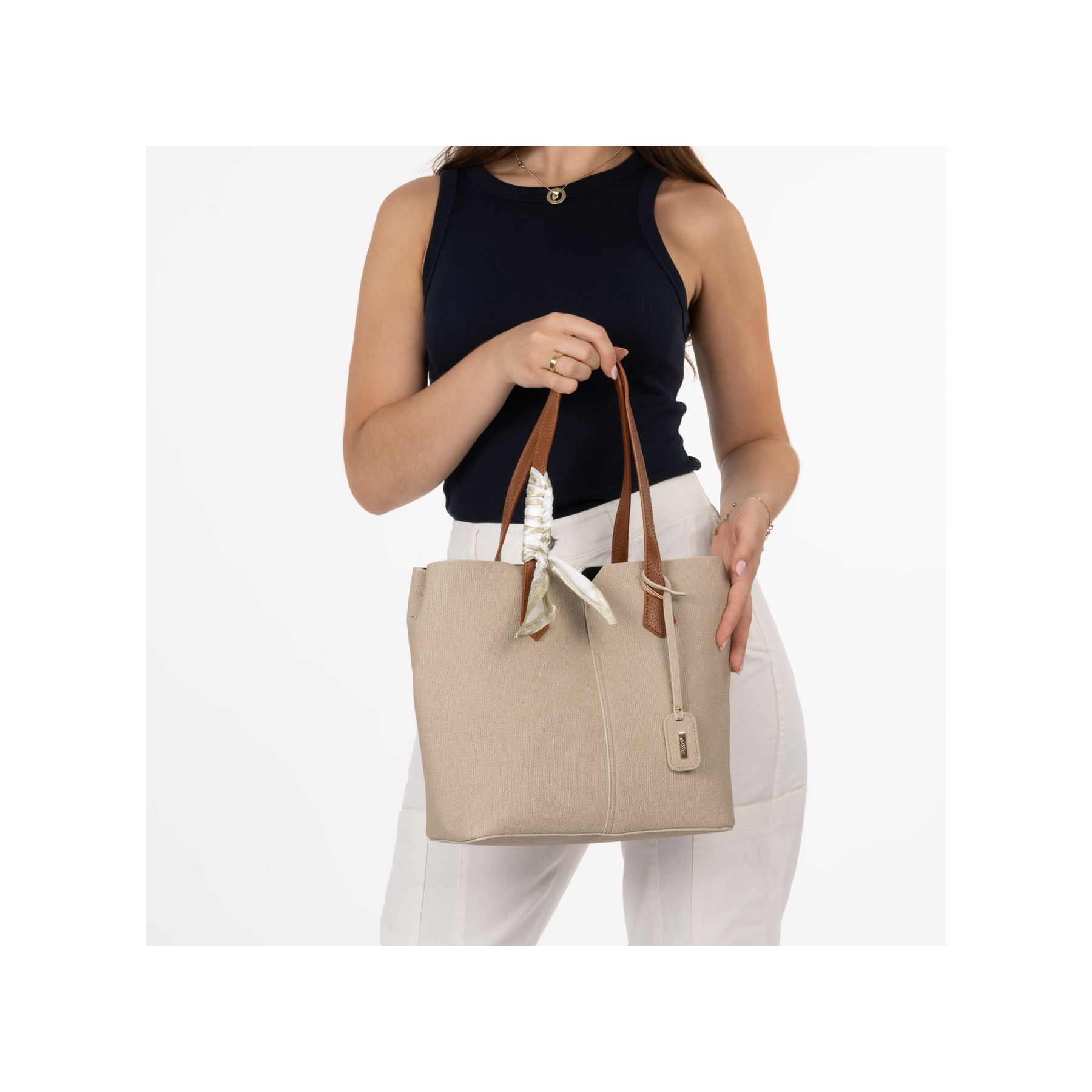 Rieker Handtasche H1045-60 in Beige mit einer Schleife aus dünnem Stoff am Henkel und geräumigem Hauptfach. Handtasche getragen.
