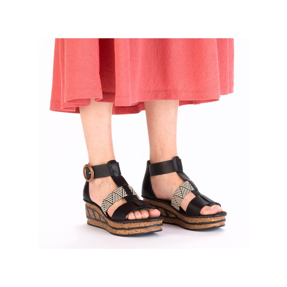 Schwarze Rieker Keilsandaletten 68182-00 mit trendiger Schnalle. Schuh am Fuß.