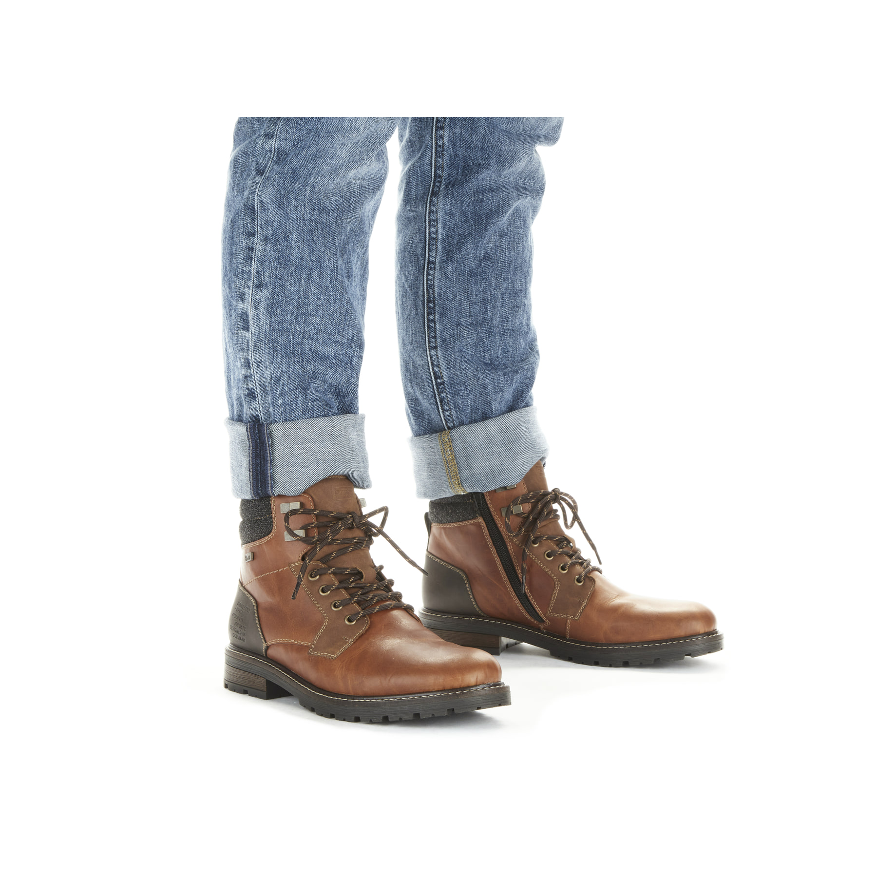 Karamellbraune Rieker Herren Schnürstiefel 32040-25 mit einer robusten Profilsohle. Schuh am Fuß