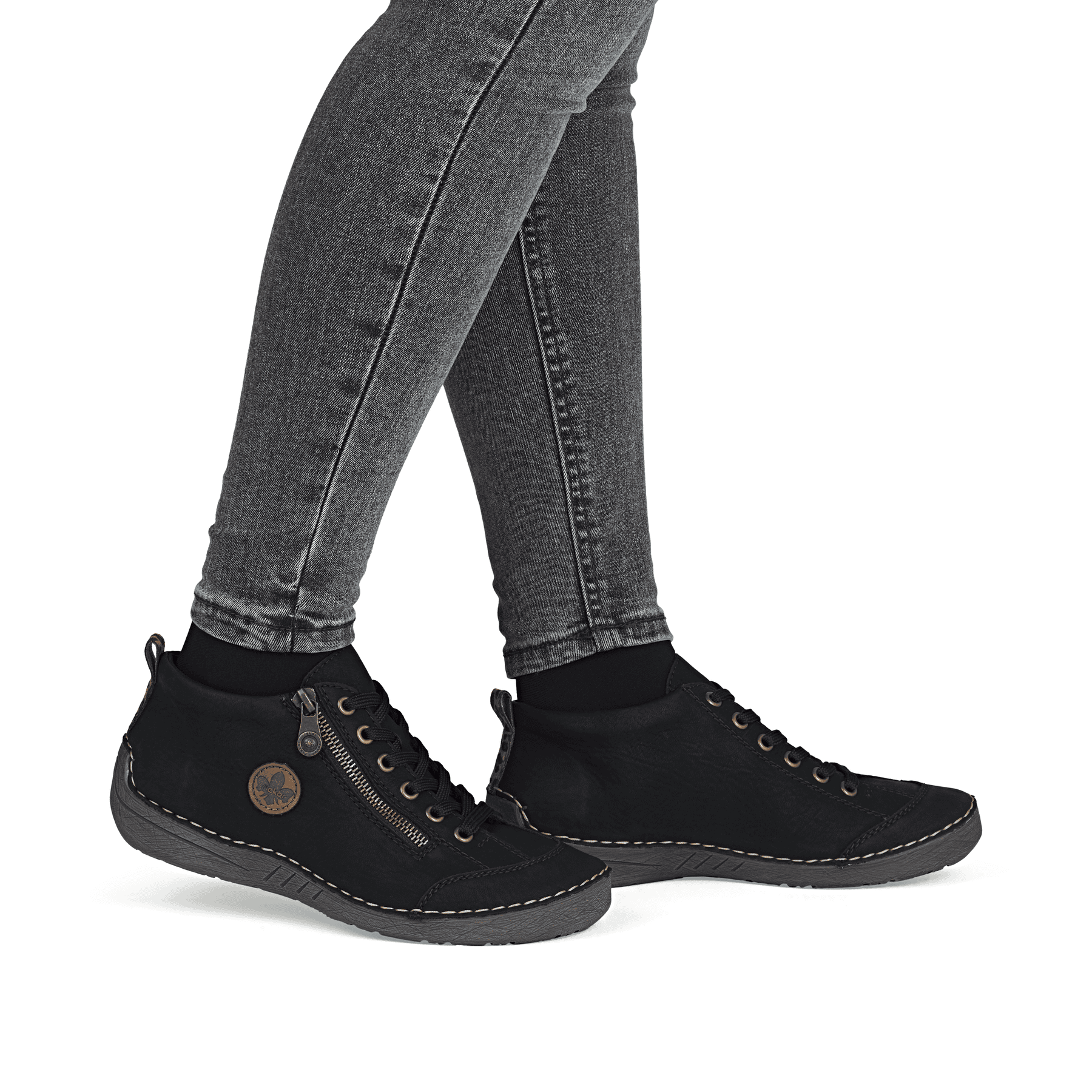Schwarze Rieker Damen Schnürstiefel 52514-00 mit auffälligem Logo. Schuh am Fuß.