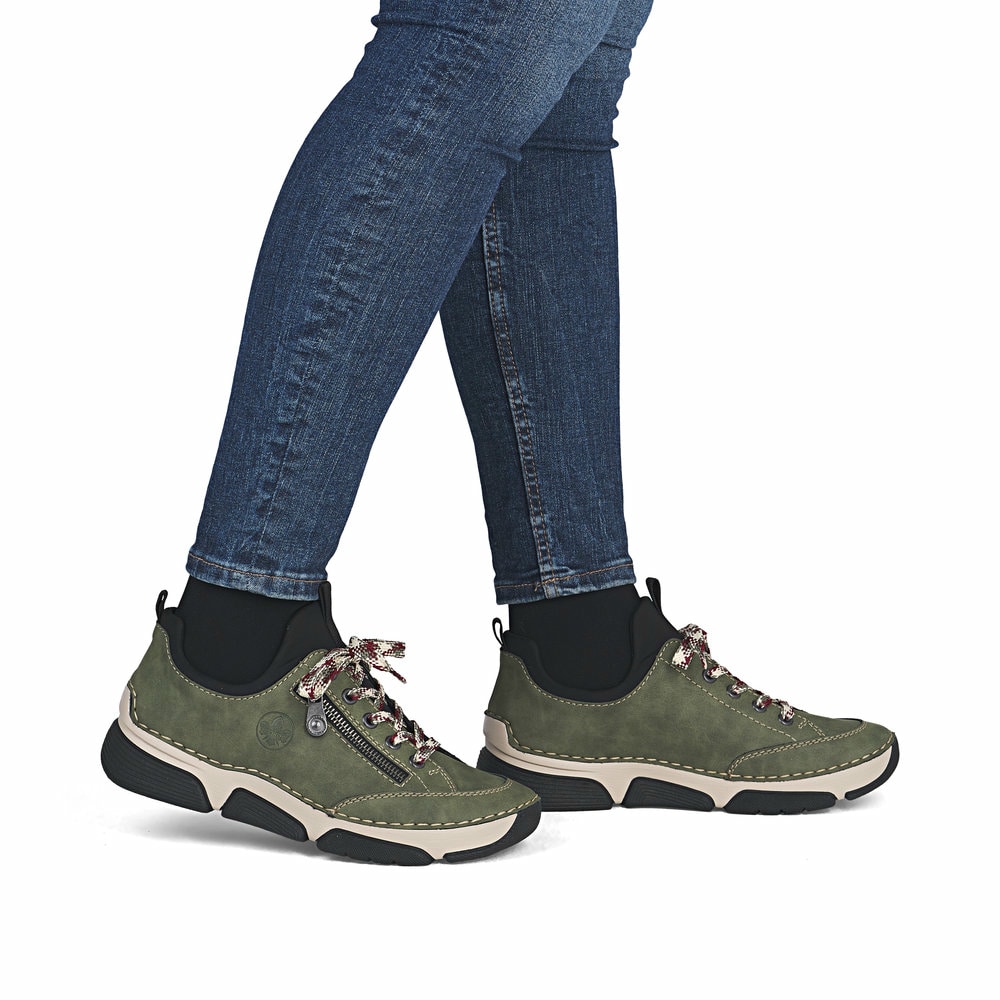 Khakigrüne Rieker Damen Slipper 45973-54 mit Elastikeinsatz sowie einer leichten Sohle. Schuh am Fuß