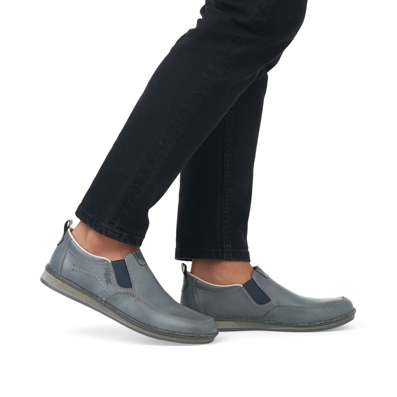 Blaue Rieker Herren Slipper 05450-12 mit Elastikeinsatz sowie braunen Ziernähten. Schuh am Fuß.