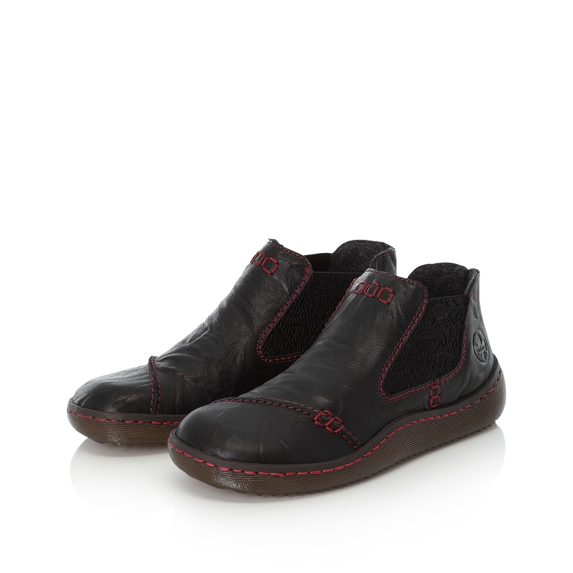 Tiefschwarze Rieker Damen Chelsea Boots L8491-00 mit roten Ziernähten. Schuhpaar seitlich schräg.