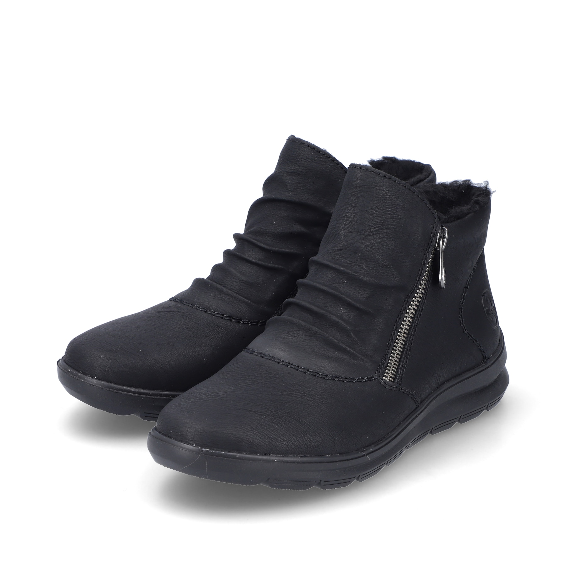 Tiefschwarze Rieker Damen Slipper Z0051-01 mit einer robusten Profilsohle. Schuhpaar schräg.