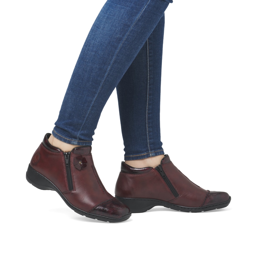 Weinrote Rieker Damen Kurzstiefel 58388-36 aus Glattleder mit dekorativer Blume. Schuh am Fuß.