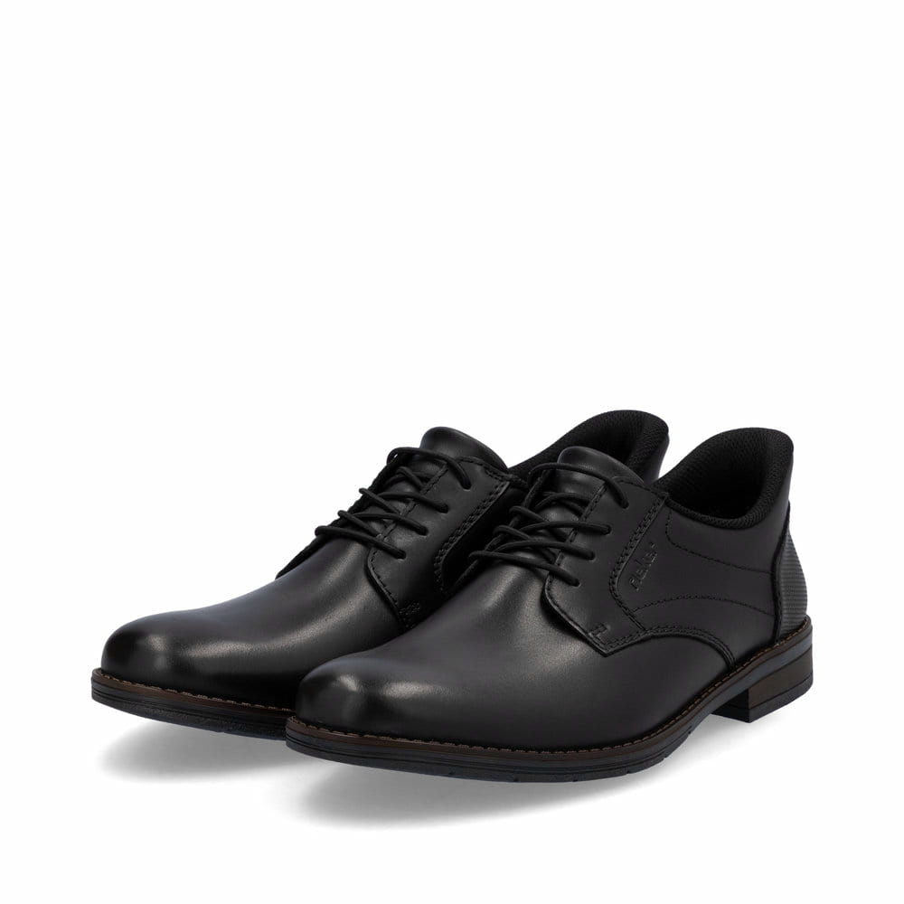 Schwarze Rieker Herren Slipper 10353-00 mit easy Hineinschlüpf-Möglichkeit. Schuhpaar seitlich schräg.