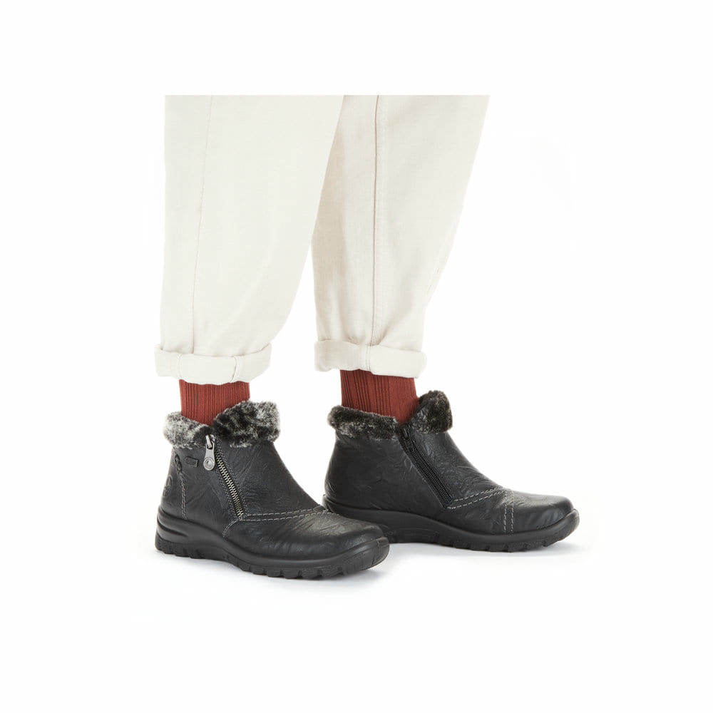 Tiefschwarze Rieker Damen Kurzstiefel L7172-00 mit einer schockabsorbierenden Sohle. Schuh am Fuß