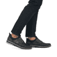 Schwarze Rieker Herren Slipper 14450-00 mit Gummizug sowie Komfortweite G 1/2. Schuh am Fuß.