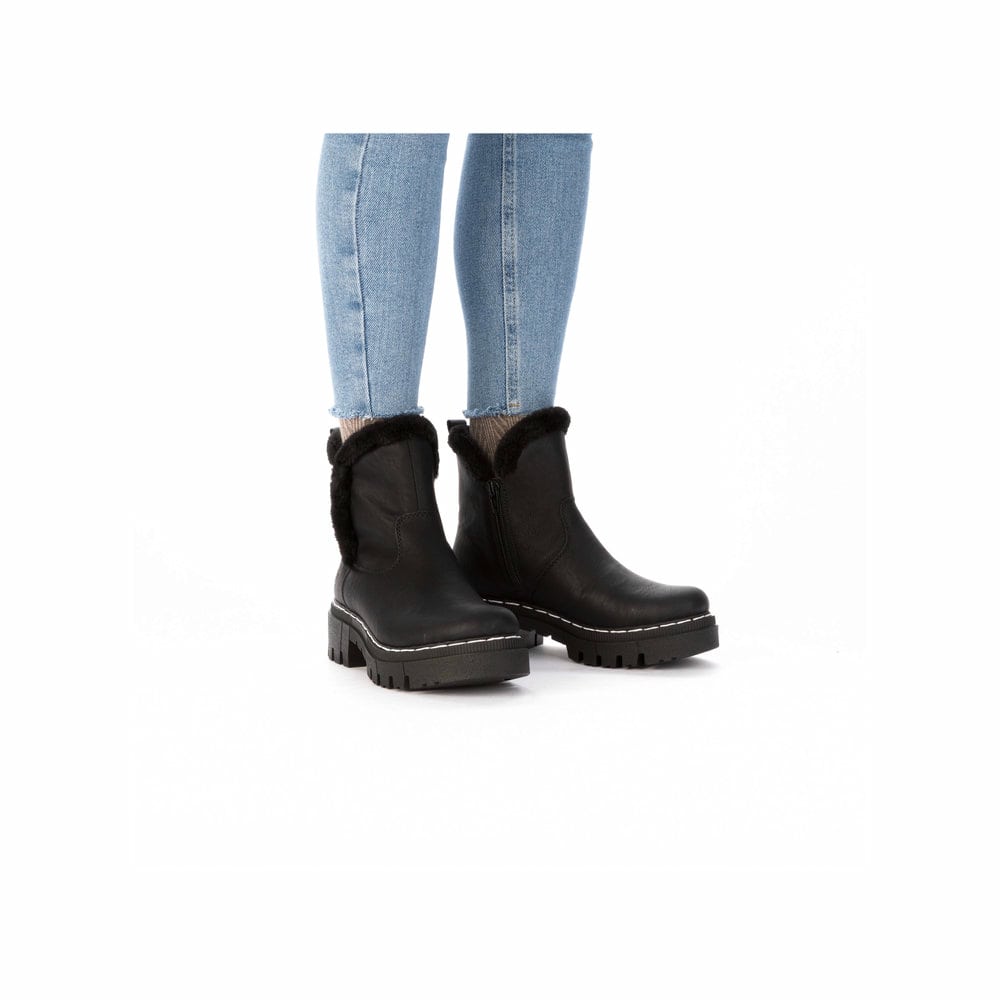 Schwarze Rieker Damen Chelsea Boots 74082-00 mit Fellschaftrand. Schuh am Fuß.