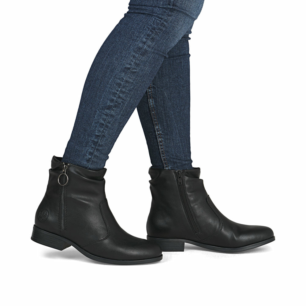 Schwarze Rieker Damen Stiefeletten 77041-00 mit einem Reißverschluss. Schuh am Fuß.