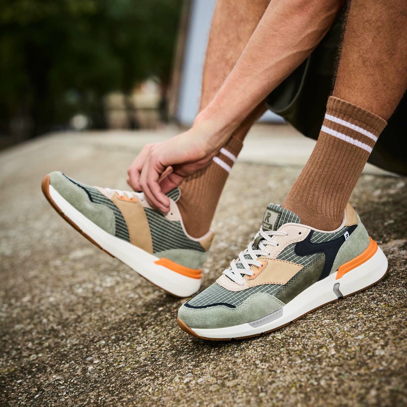 Grüne Rieker Herren Sneaker Low U1402-54 mit Schnürung sowie flexibler Sohle. Schuh am Model. 