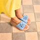 Blaue Rieker Damen Pantoletten V1562-10 mit dekorativer Blume. Schuh am Model.