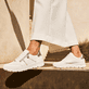 Weiße Rieker Damen Sneaker Low N1313-80 mit Reißverschluss sowie Extraweite H. Schuh am Model.