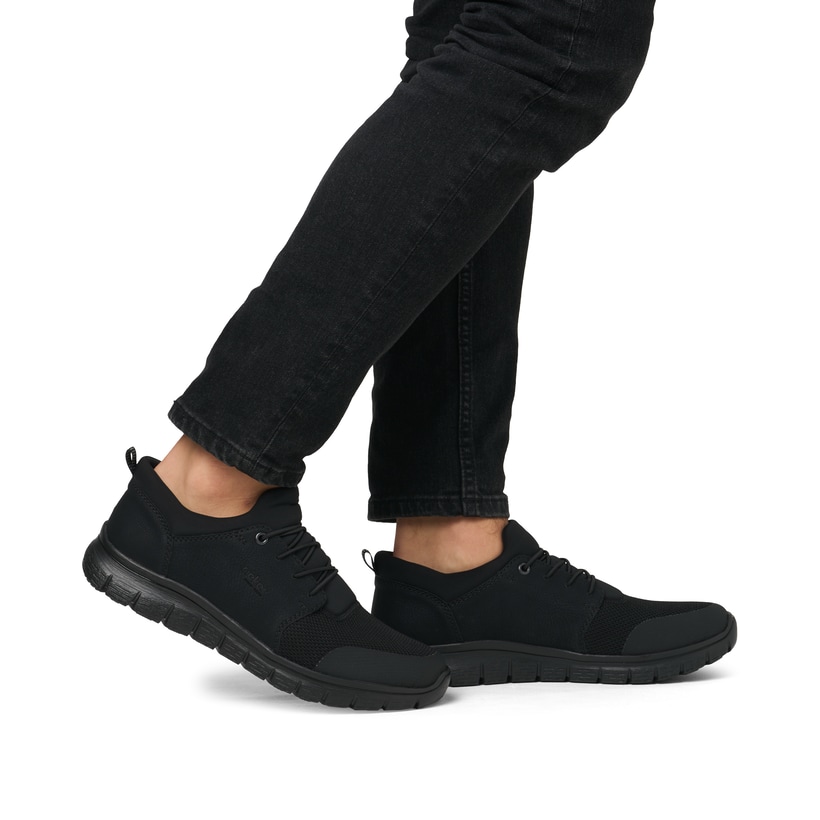 Schwarze Rieker Herren Slipper B6650-00 mit Gummizug sowie Komfortweite G 1/2. Schuh am Fuß.