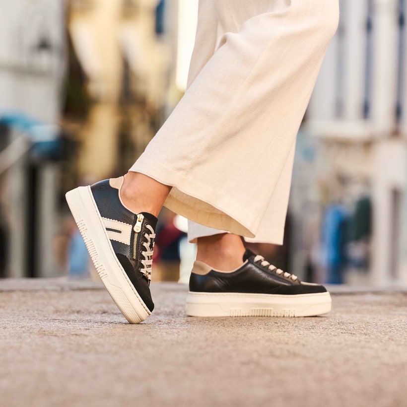 Schwarze Rieker Damen Sneaker Low M1912-00 mit einem Reißverschluss. Schuh am Model.