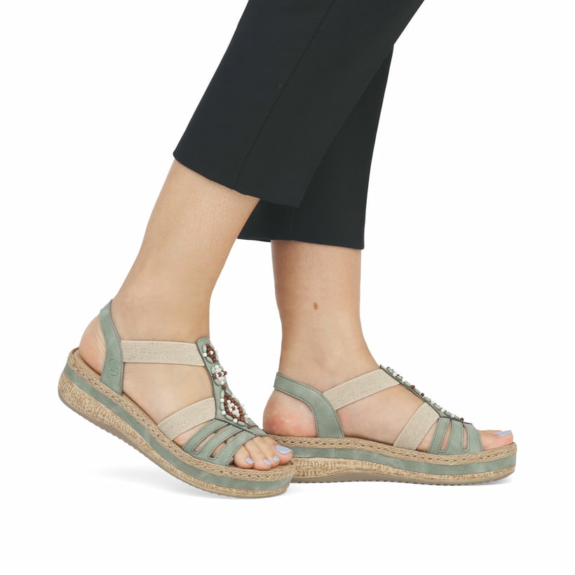 Grüne Rieker Keilsandaletten V0920-52 mit Schmuckelementen sowie einem Gummizug. Schuh am Fuß.