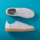 Weiße Rieker Damen Sneaker Low W2200-80 mit Schnürung sowie abriebfester Sohle. Schuhpaar von oben, seitlich auf blauem Hintergrund.