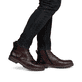 Nussbraune Rieker Herren Schnürstiefel F3604-25 mit einer robusten Profilsohle. Schuh am Fuß