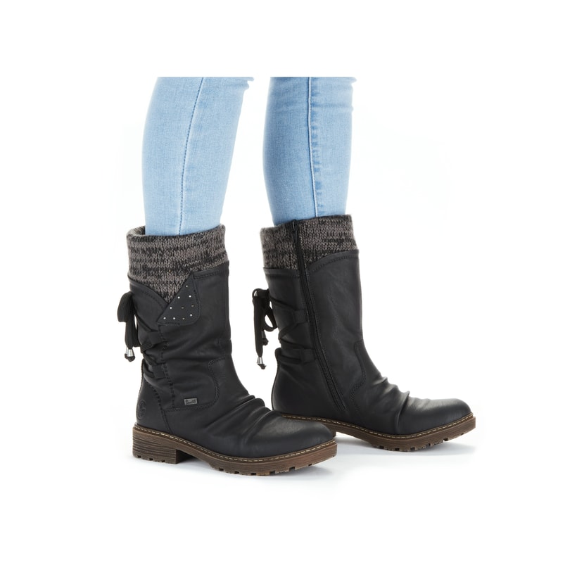 Tiefschwarze Rieker Damen Kurzstiefel Z4773-01 mit einer robusten Profilsohle. Schuh am Fuß