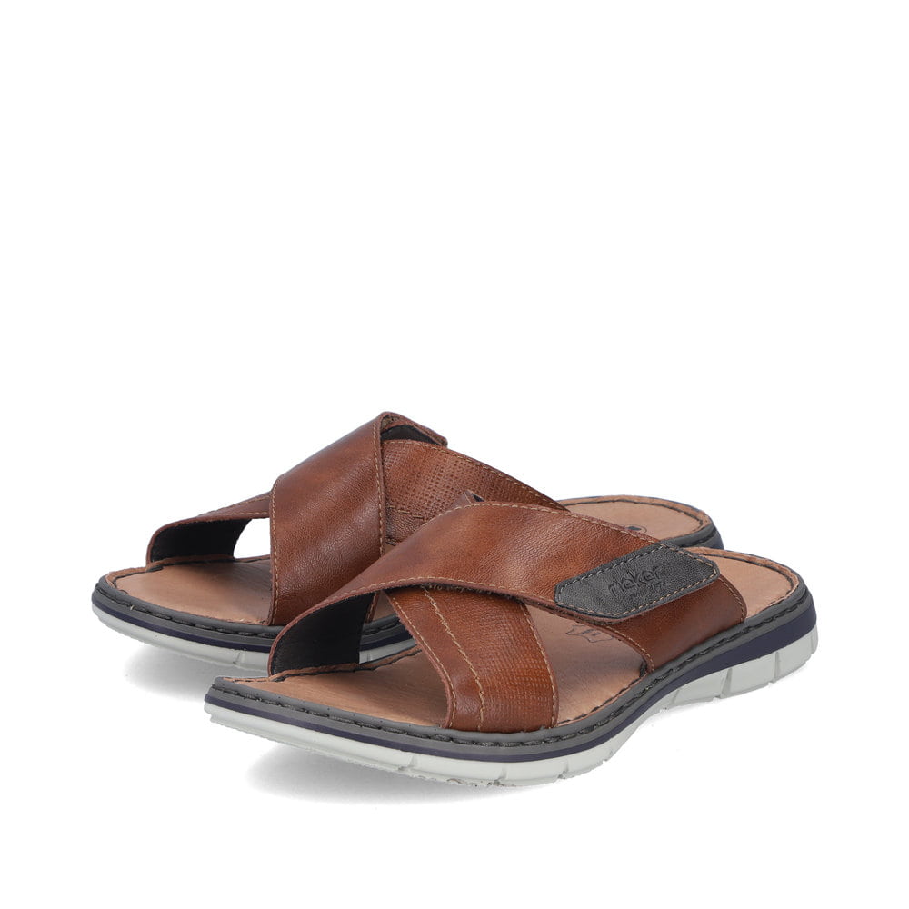 Braune Rieker Herren Pantoletten 25151-24 aus Glattleder mit Klettverschluss. Schuhpaar seitlich schräg.