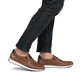 Braune Rieker Herren Slipper 11950-25 mit Gummizug sowie der Komfortweite G 1/2. Schuh am Fuß.