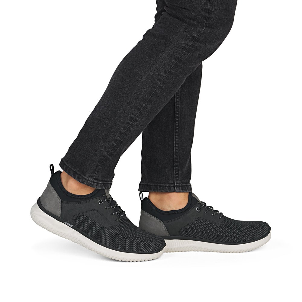 Schwarze Rieker Herren Slipper B9651-00 mit einem Gummizug sowie Komfortweite G. Schuh am Fuß.