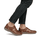 Braune Rieker Herren Slipper 03578-24 mit Klettverschluss sowie der Extraweite H. Schuh am Fuß.