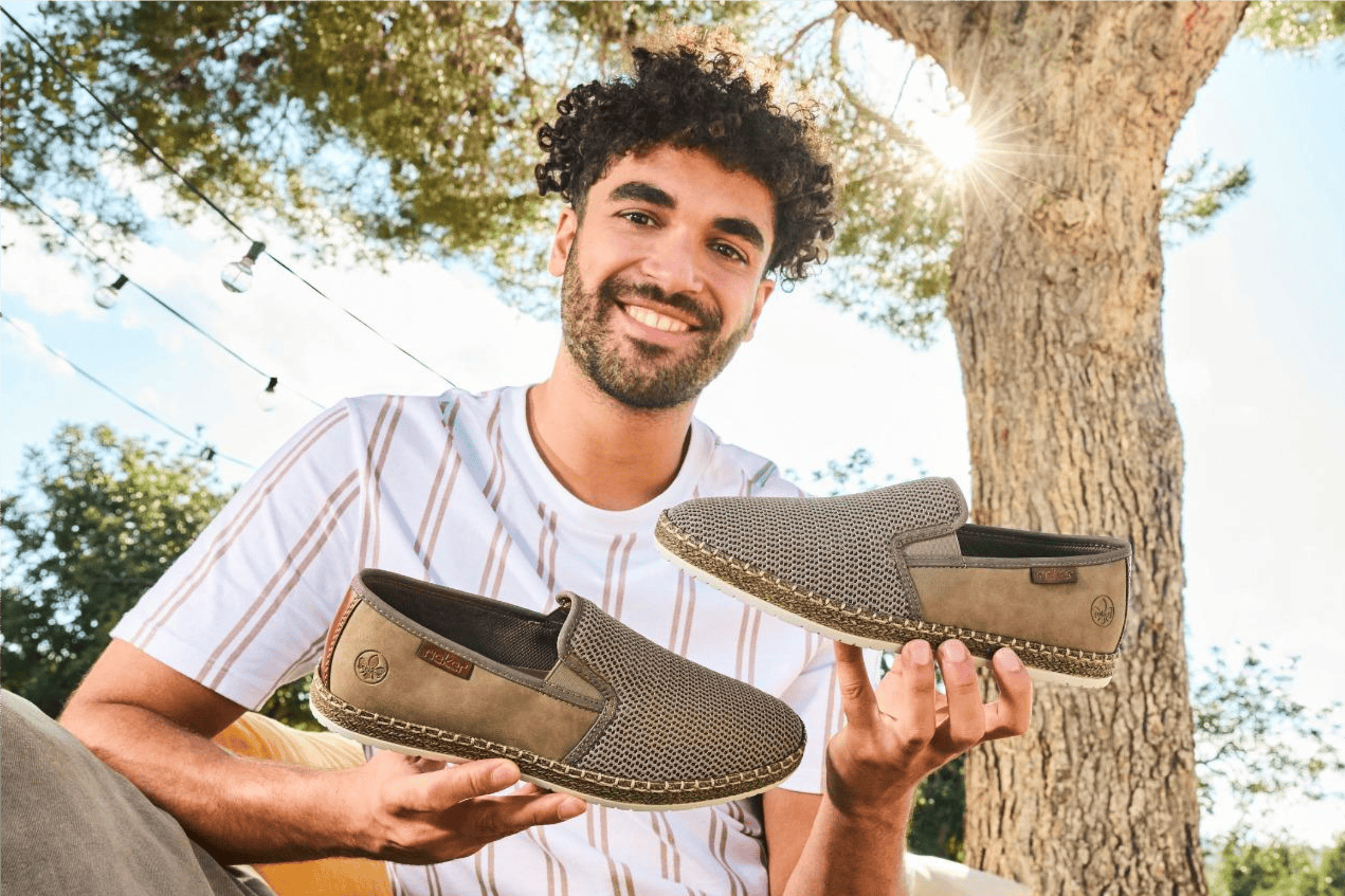 Mann hält beige Herren Slipper b5265-65 von Rieker.