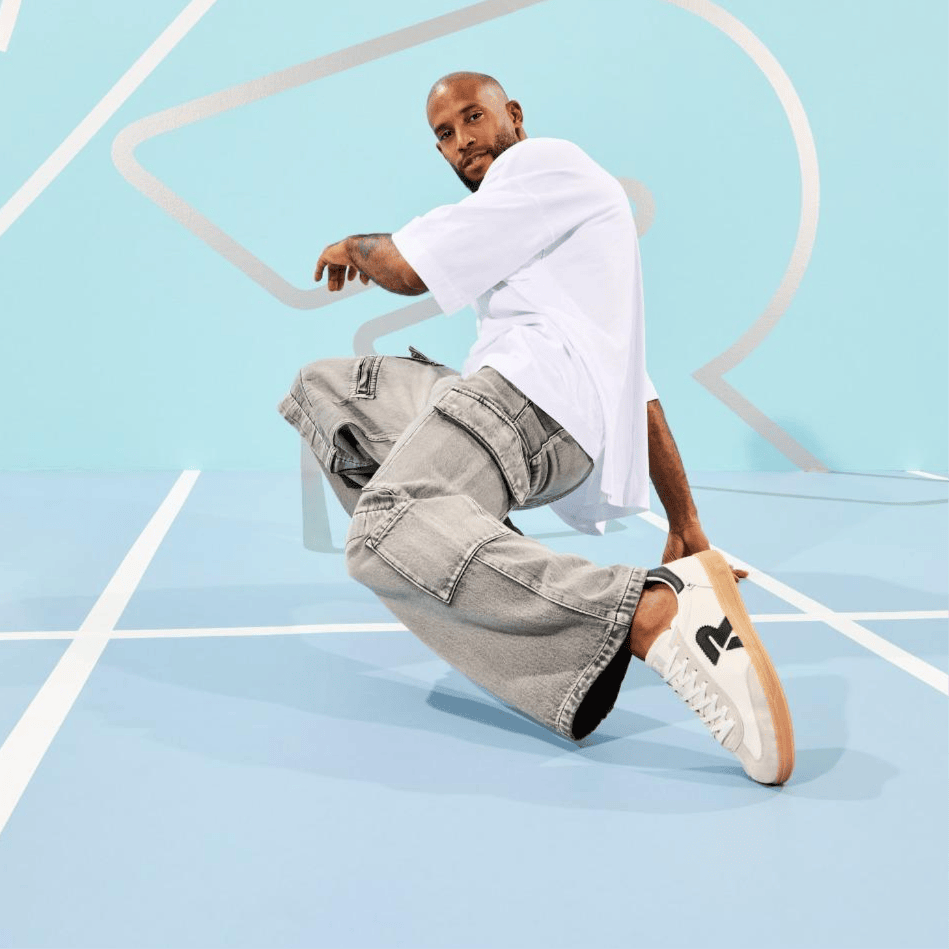 Homme dansant le breakdance, s\'appuyant d\'une main sur le sol et portant des Sneakers San Diego U2200-83 de Rieker.