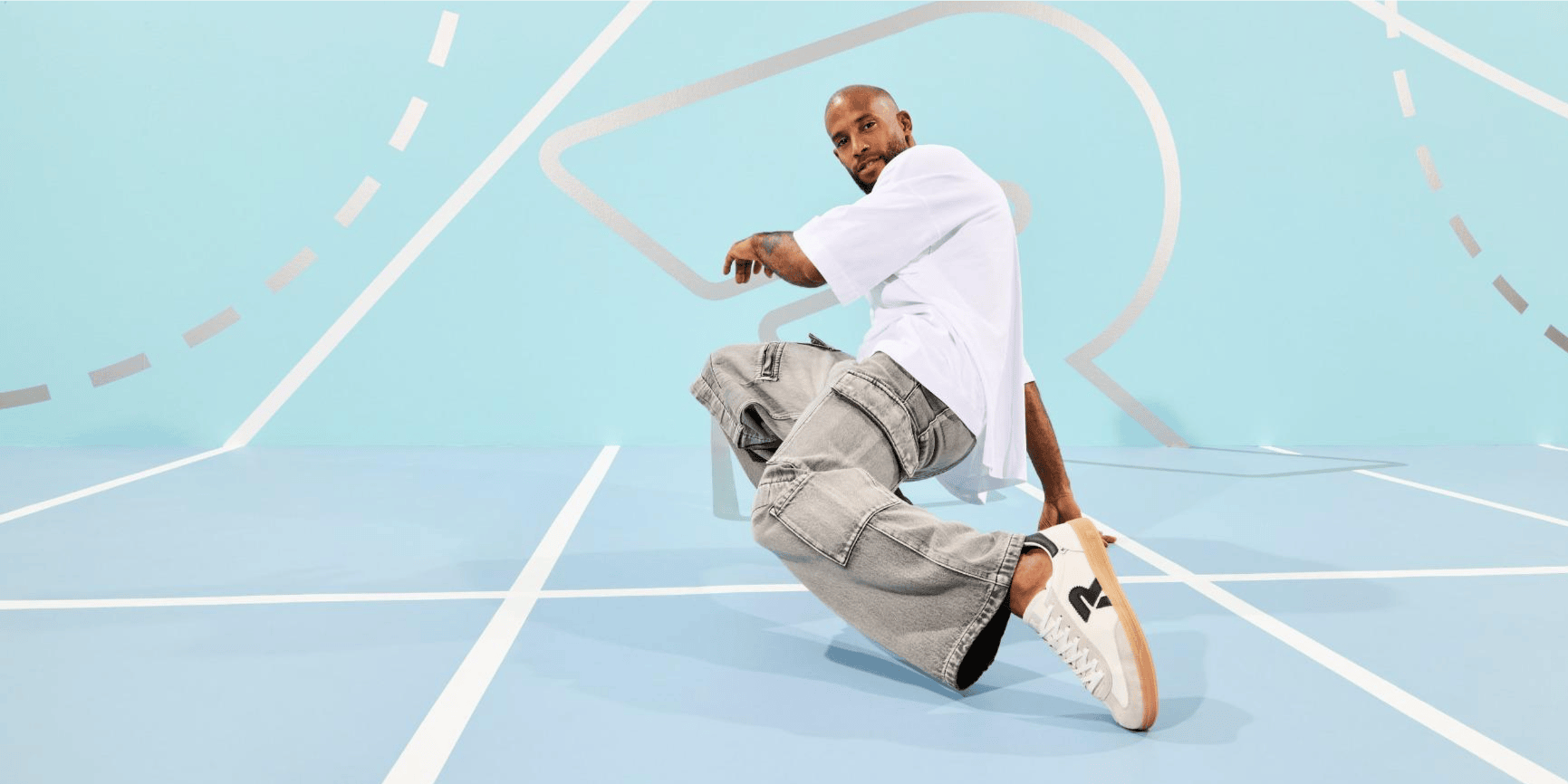 Homme s\'appuyant d\'une main sur le sol et portant des Sneakers San Diego U2200-83 de Rieker.