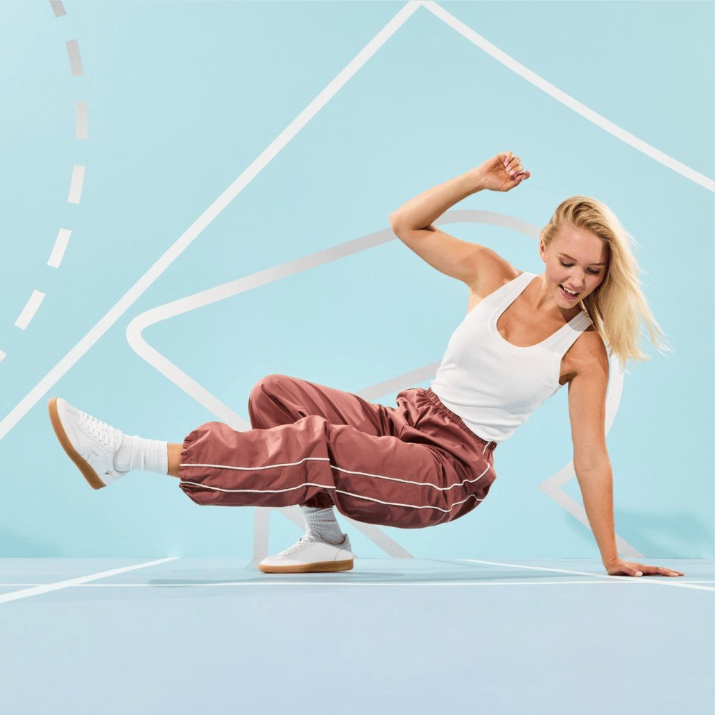 Une femme danse le breakdance avec San Diego W2200-80 de Rieker dans une salle.
