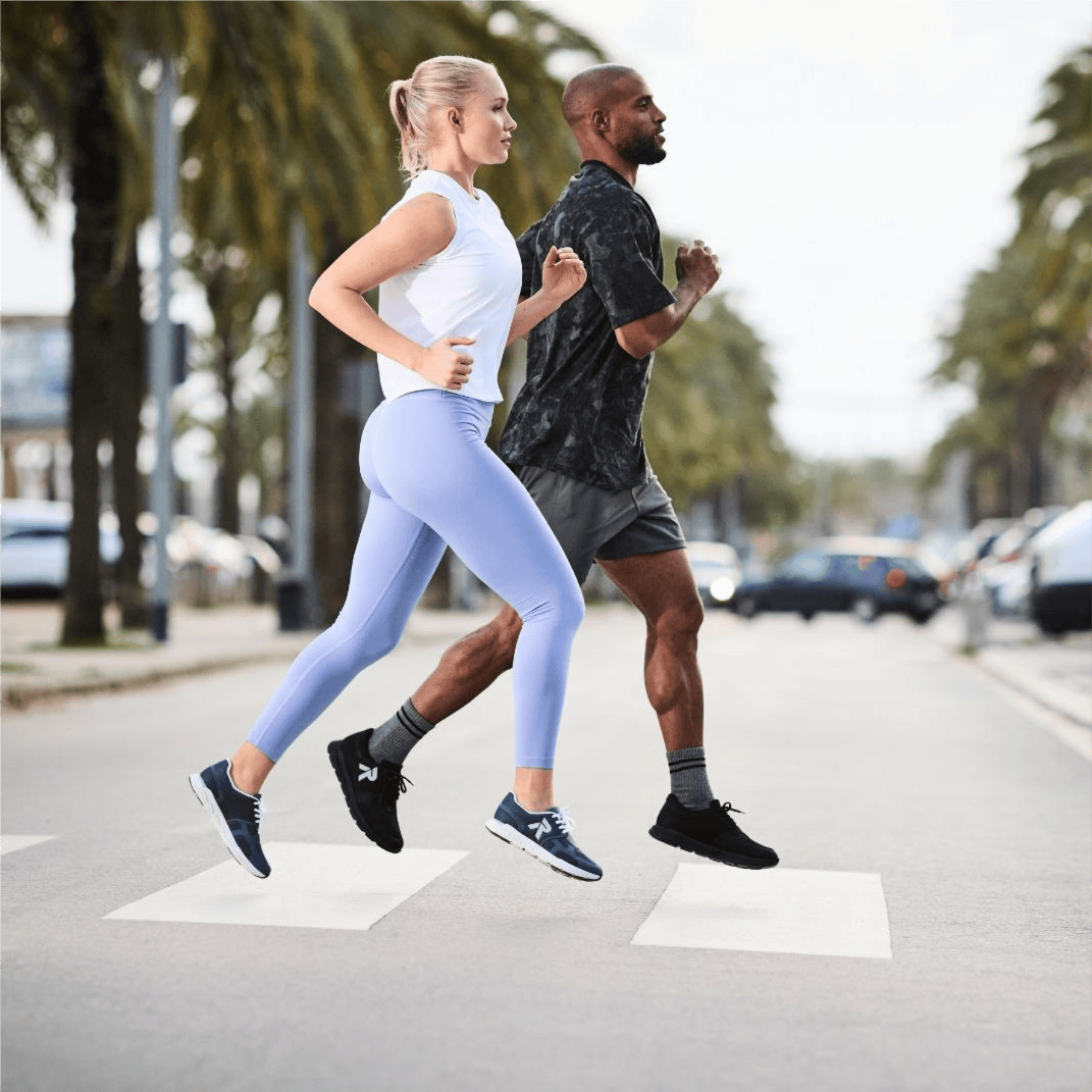 L\'homme et la femme font leur jogging sur la route en chaussures de sport Rieker Preston 09100-00 et M9000-12.