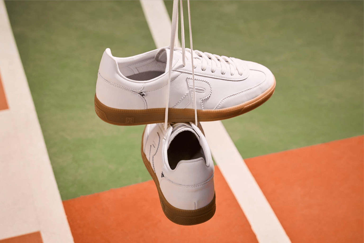 Rieker Herren Sneaker low San Diego u2200-80 in weiß sind an den Schnürsenkeln aufgehängt.