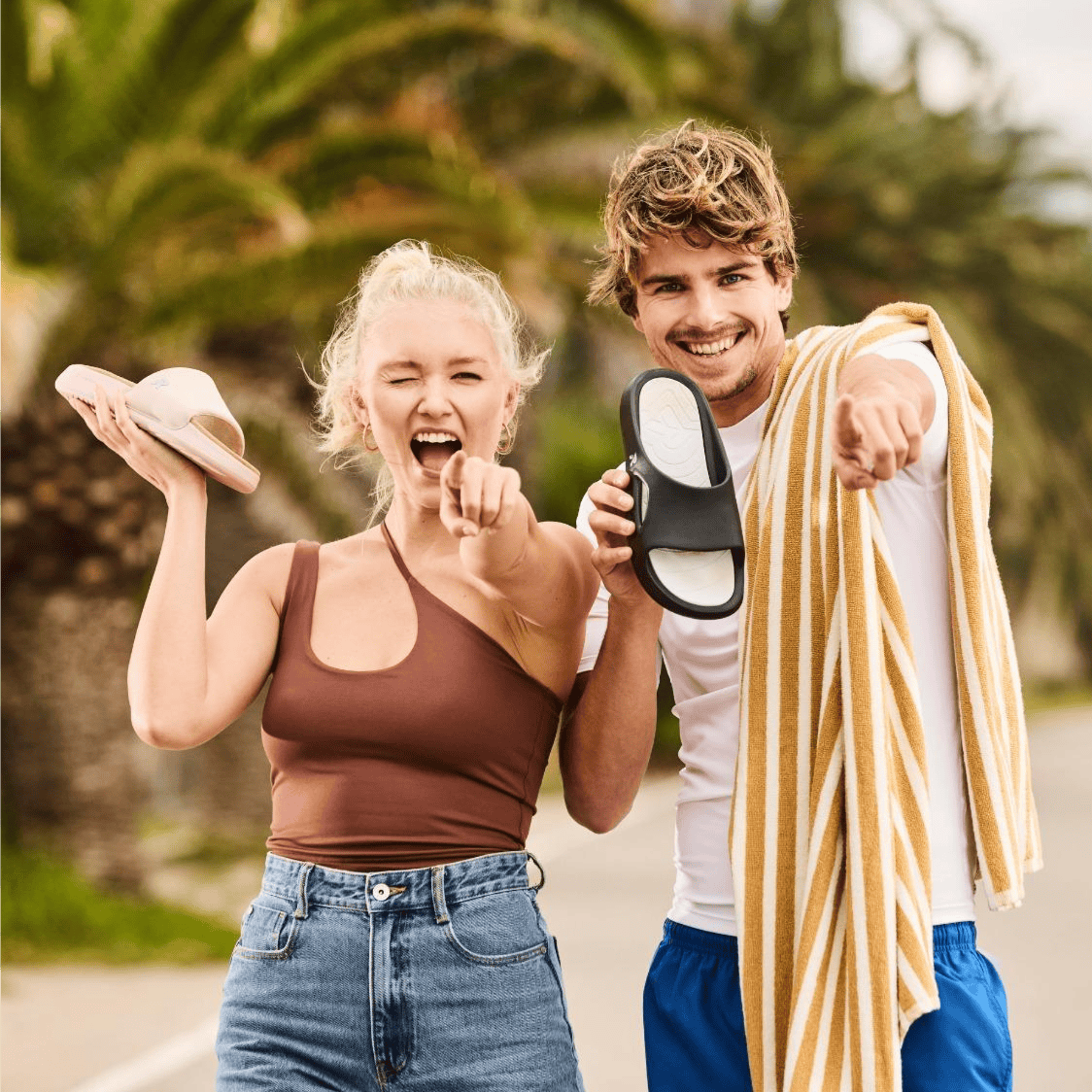 La femme et l\'homme tiennent dans leurs mains des slides U3450-00 et W3250-31 de Rieker.