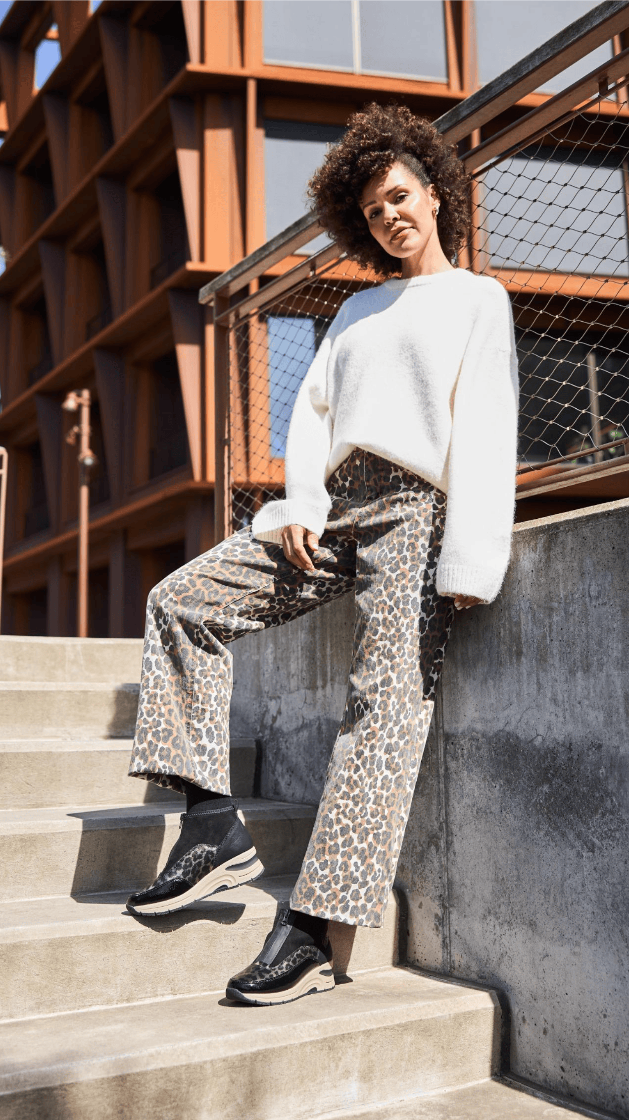 Femme portant des baskets montantes n9362-00 avec l\'imprimé animal de Rieker.