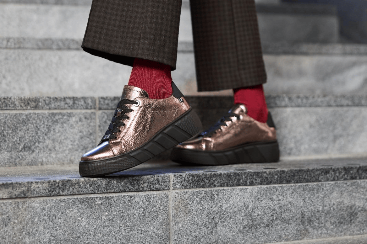 Une femme porte le nouveau modèle de chaussures w2601-91 de Rieker.