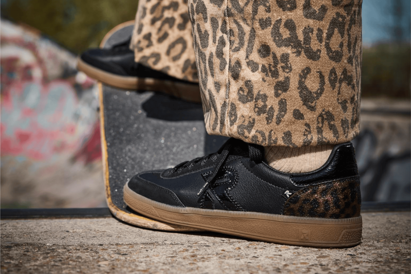 Une femme portant des baskets basses avec imprimé animal compensées w2200-03 de Rieker.